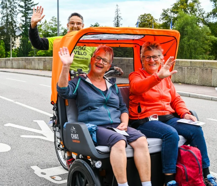 Animation vélo adapté : deux passagers saluent depuis un Chat